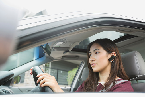 Young driver behind the wheel using a hands-free device.