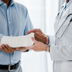 Personal injury victim with a cast on his arm speaking with doctor