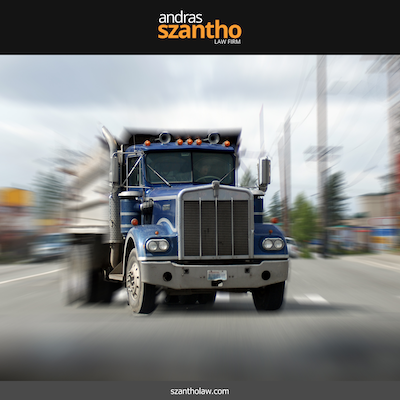 Blue dump truck driving on a street in Santa Fe, NM