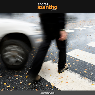 Pedestrian walking in an crosswalk with a car approaching in Albuquerque, New Mexico