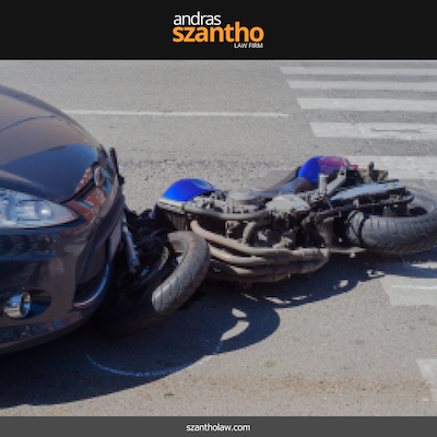 Motorcycle lying on the road after a collision with a car at an intersection in Albuquerque